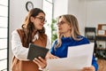 Two business workers woman reading paperwork using touchpad at the office Royalty Free Stock Photo