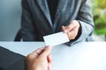 Two businessman holding and exchanging empty business card in officeTwo businessman holding and exchanging empty business card Royalty Free Stock Photo