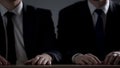 Two businessman sitting with hands on table at court hearings, law and justice Royalty Free Stock Photo