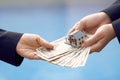 Two businessmen conduct a house sale with a model house and Yen banknotes valued at 10000 yen.using as background business concept