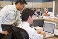 Two businessmen in cubicle looking at laptop Royalty Free Stock Photo