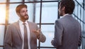 two businessmen discuss the document standing in the office lobby. Royalty Free Stock Photo