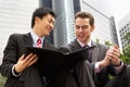 Two Businessmen Discussing Document Outside Office