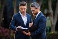 Two businessmen discussing outdoor. Two business people talk project strategy. Two american businessmen in suits walk Royalty Free Stock Photo