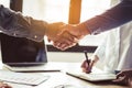 Two businessmen handshaking in meeting after final project agreement deal done