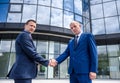Two businessmen handshaking near skyscraper outdoors Royalty Free Stock Photo