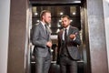 Two businessmen have talk in elevator