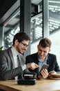 Two businessmen having a conversation using a smartphone Royalty Free Stock Photo