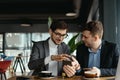 Two businessmen having a conversation using a smartphone Royalty Free Stock Photo