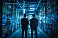 Two businessmen having a discussion in a modern data center, surrounded by servers and cables. Concept of network security and inf Royalty Free Stock Photo