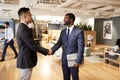 Two Businessmen Meeting And Shaking Hands In Modern Open Plan Office Royalty Free Stock Photo