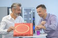 two businessmen preparing to eat take-away pizza