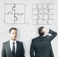 Two businessmen and puzzle parts on light wall