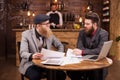 Two businessmen reading documents during their meeting in a coffee shop Royalty Free Stock Photo