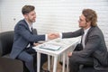 Two businessmen shake hand for contact and startup new project together on sofa indoors, Business and New project launch contact Royalty Free Stock Photo