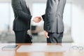 Two businessmen shake hands in the office