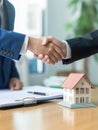 Two businessmen shaking hands in front of house model Royalty Free Stock Photo