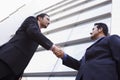 Two businessmen shaking hands outside office build Royalty Free Stock Photo