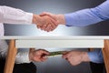 Two Businessmen Shaking Hands And Receiving Bribe Royalty Free Stock Photo