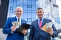 Two businessmen showing dollar and euro banknotes