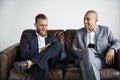 Two businessmen sitting on a couch