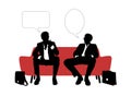 Two businessmen speaking seated on red sofa