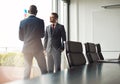 Two businessmen standing talking together