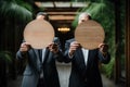 Two businessmen in suits holding wooden plates