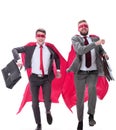 Two businessmen in superhero capes running forward