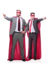 Two businessmen in superhero raincoats pointing in different directions.