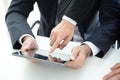 Two businessmen using tablet computer with one hand touching screen Royalty Free Stock Photo