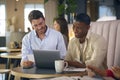 Two Businessmen Working On Laptop In Informal Seating Area Of Modern Office On Coffee Break Royalty Free Stock Photo