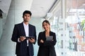 Two businesspeople holding digital tablet and looking confidently at camera. Royalty Free Stock Photo