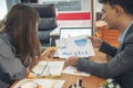 Two businesspeople meeting team discuss using laptop look at financial graph chart in office desk. Two young businessman reading Royalty Free Stock Photo