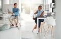 Two businesspeople talking while working in an office together. Young asian businessman talking to an african american Royalty Free Stock Photo