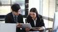 Two businesspeople using computer tablet and discussing business report in office. Royalty Free Stock Photo