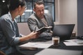 Two businesspeople working together at a table in an office Royalty Free Stock Photo