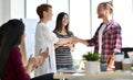 Two businesspersons shaking hands in agreement with congratulating