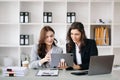 Two businesswoman discuss investment project working and planning strategy with tablet laptop computer in office