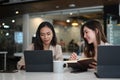 Two businesswoman partners discussing together on business project and using computer tablet.