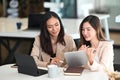 Two businesswoman using digital tablet and working together on project at modern office. Royalty Free Stock Photo