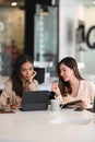 Two businesswomen are collaborating and discussing project plans while using a digital tablet. Royalty Free Stock Photo