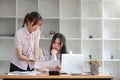 Two businesswomen colleagues working together look at laptop screen, talking about project, thinking, search solution Royalty Free Stock Photo