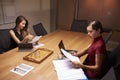 Two businesswomen doing paperwork late in an office