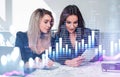 Two businesswomen in formal wears working together using tablet device. Office background. Overlay of digital forex financial