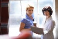 Two Businesswomen Having Informal Meeting In Office