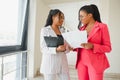 Two Businesswomen Shaking Hands In Lobby Of Modern Office Royalty Free Stock Photo