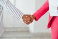 Two Businesswomen Shaking Hands In Lobby Of Modern Office Royalty Free Stock Photo