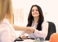 Two businesswomen shaking hands in modern office. Royalty Free Stock Photo