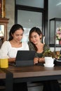 Two businesswomen sitting at desk working together on project analyzing stats. Royalty Free Stock Photo